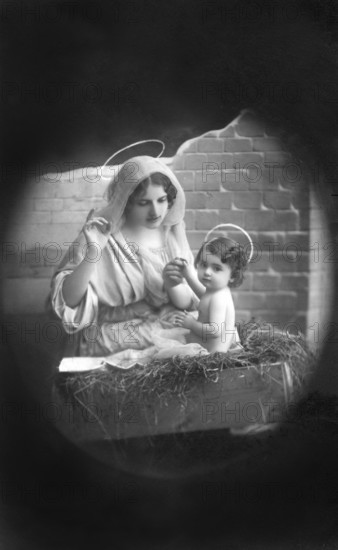 Mary and Jesus with halo, 1930s, Religious depiction of a woman with a halo holding a child, as in a nativity scene scene, Historical photo