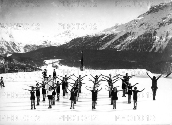Children doing morning exercises in the snow around 1940, children practising in a choreographed group in a snowy mountain landscape, historical photo