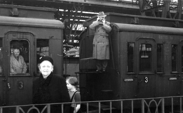 Train station hall photographer, 1930s, people on a platform, a man photographed from a carriage, historical photo