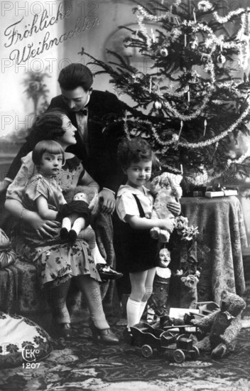 Family Christmas tree, 1930s, Christmas family scene with decorated tree, parents and children with toys, historical photo