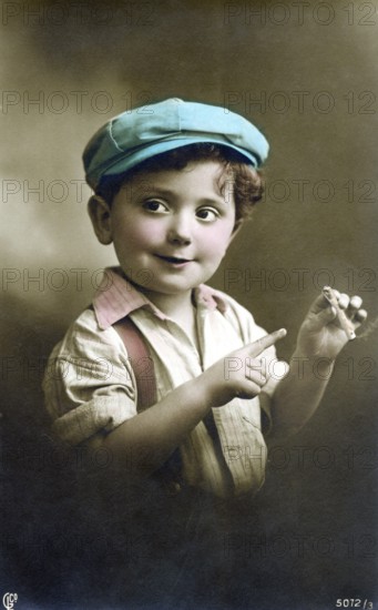 Little boy with a cigarette, 1930s, A boy in a colourful cap and shirt playfully holds a cigar and smiles, Historical photo