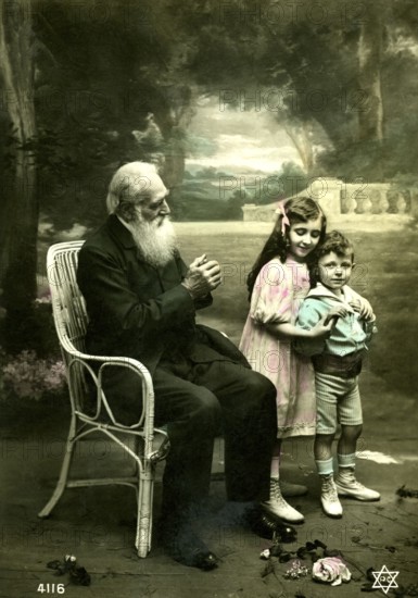Grandpa with 2 children, 1910, An elderly man sits in the garden with two children standing happily next to him, Historical photo