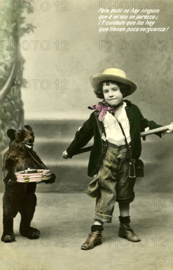 Boy with toy bear on a leash, 1910s, A child poses with a small bear carrying a toy box, Historical photo
