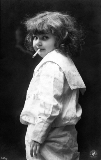 Girl smoking a cigarette, 1920, A child with a cigarette in her mouth, in a striking and incongruous vintage black and white photo, Historical photo