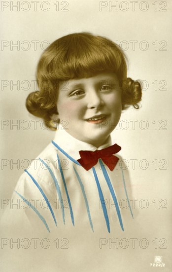 Portrait of a girl, 1920, girl in a striped shirt with a red bow, friendly and warm smile, historical photo
