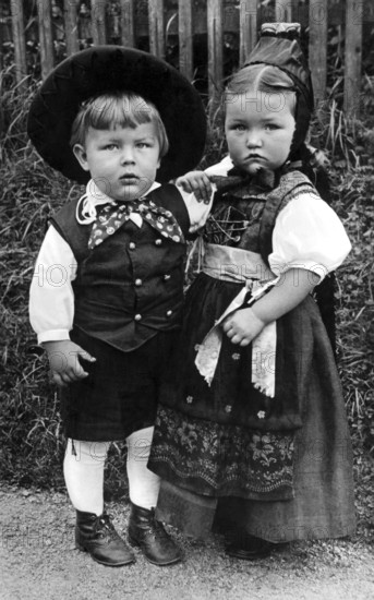 2 children in traditional costumes, Black Forest, 1920, Two children in traditional costumes standing next to each other, serious facial expression, Historical photo