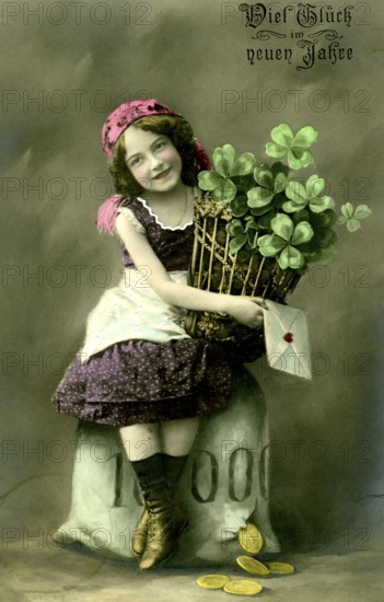 Girl with lucky clover, 1910, Girl with a bouquet of shamrocks and New Year's message, sitting on a stone, historical photo