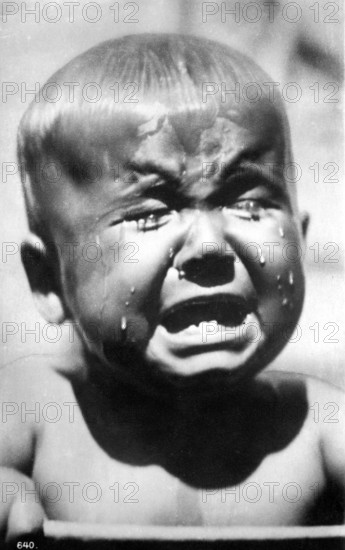 Crying child, 1920, A little boy cries bitterly, tears stream down his face in a black and white picture, Historical photograph