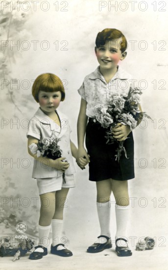 Brother and sister, 1920, Two children in elegant clothes holding flowers, radiating gentleness and innocence, Historical photo