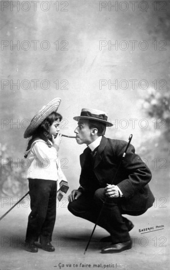 Man gives girl a light, 1910, A man in a suit and a girl exchange humorous glances while smoking a pipe, Historical photo