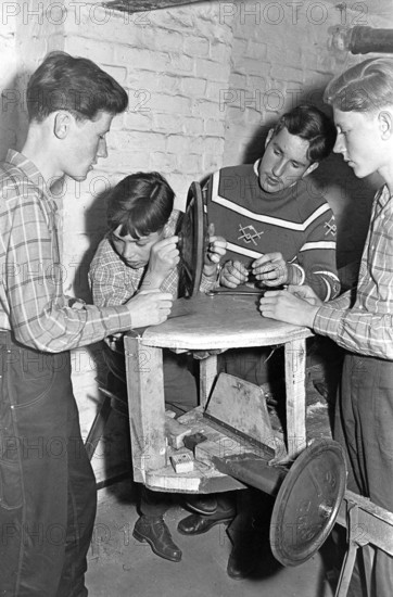 Four young people in a workshop, 1950s, boys working together on a wood project in a workshop, historical photo