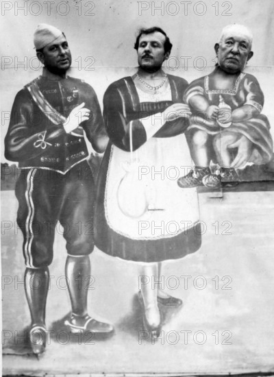 Screen with three men as mother, father and child, 1920s, Surreal presentation of three people in costumes in front of a painted background, Historical photo