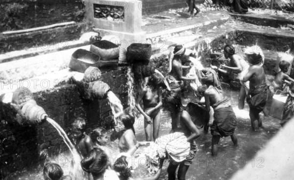 Women and children taking a shower, 1920s, Children bathing together under taps at a public watering place, historical photo