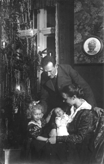 Christmas Eve, 1920s, family in the living room with Christmas tree and candles, festive atmosphere, historical photo
