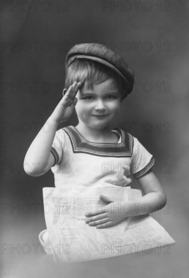 Little boy, 1920s, child with cap holding a newspaper and greeting, black and white photo with nostalgic flair, historical photo