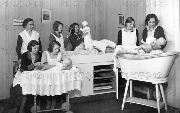 Midwifery school, 1930s, woman in uniforms, caring for dolls in a classical room, training situation, historical photo