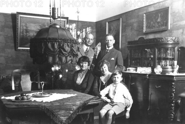 Family photo, 1920s, Family scene in an antique furnished living room with paintings and furniture, Historical photo