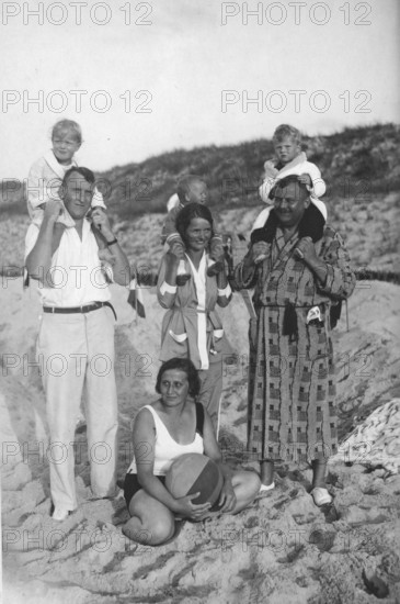 Family on the beach, 1920s, family photo on the beach with adults and children, children sitting on shoulders, nostalgic atmosphere, historical photo