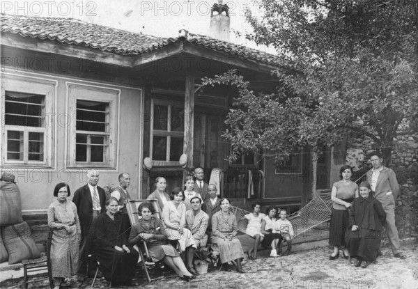 Family photo, 1920s, Group of people in front of a traditional house on the veranda, Historical photo