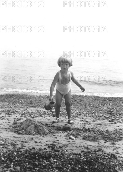 Little girl on the beach, 1920s, Young boy on the beach with bucket in hand, black and white photograph, Historical photograph