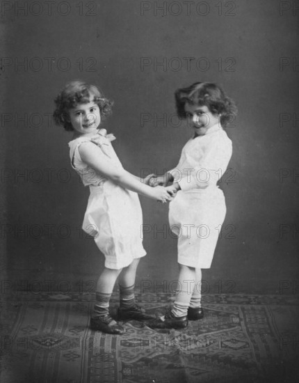 Two small children holding hands, 1920s, Two children holding hands and smiling, black and white photograph, Historical photograph