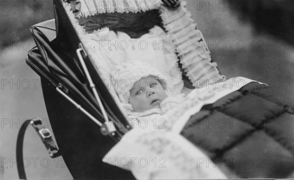 Baby in pram, 1920s, Baby lying in an old-fashioned pram, looking into the camera, black and white, Historical photo