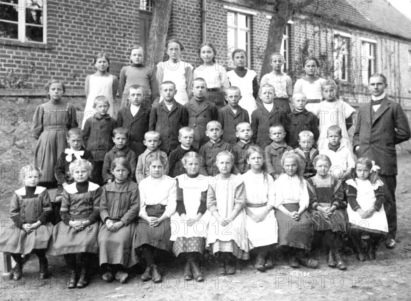 School class with teacher, 1920s, Group photo of a school class with teacher in front of a brick building, Historical photo