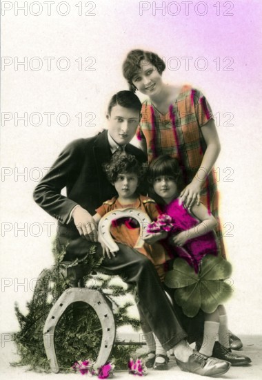 Horseshoe lucky family, 1910, A family poses together with lucky symbols such as horseshoe and cloverleaf, historical photo