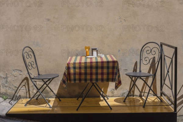 A small table and two chairs in the street in front of a café, Montepulciano, Province of Siena, Tuscany, Italy