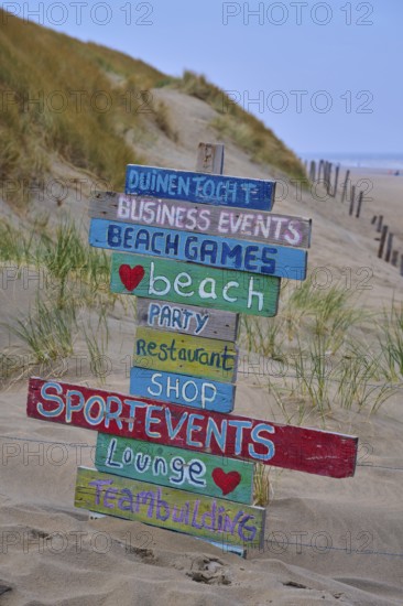 Wooden signs with colourful lettering stand in the dune sand on the beach, beach section 27, Noordwijk, North Sea, province of South Holland, Netherlands