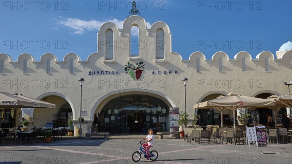 Traditional market square with iconic architecture and playing child, Agora, Market Hall, Kos Town, Kos, Dodecanese, Greek Islands, Greece