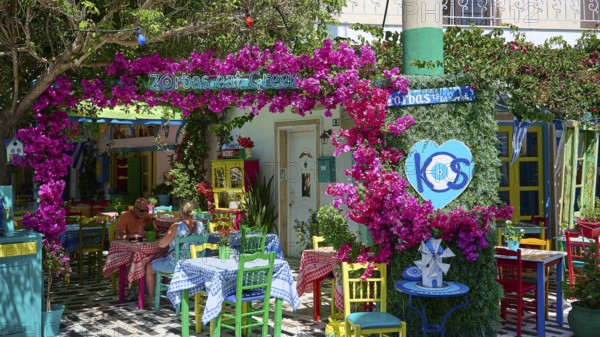 Cosy taverna with flowers and colourful furniture, sunny and welcoming atmosphere, Platia Diagora, Kos Town, Kos, Dodecanese, Greek Islands, Greece