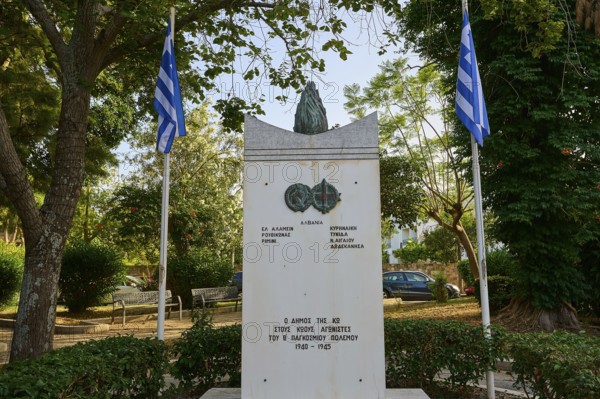 Monument in a park-like setting with flags and surrounded by lush trees, Memorial, Wars 1940-1945, Kos Town, Kos, Dodecanese, Greek Islands, Greece