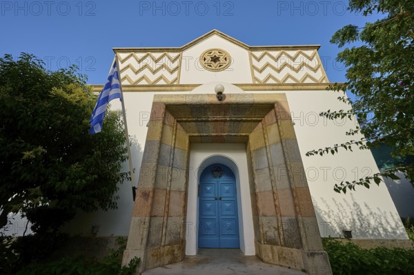 Greek architecture with turquoise door and flag on bright, sunny background, Synagogue, Kos Town, Kos, Dodecanese, Greek Islands, Greece