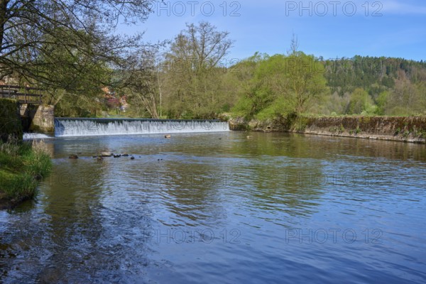 Water flows calmly through a green landscape surrounded by forest in spring, spring, Obersinn, Sinntal, Spessart, Bavaria, Germany