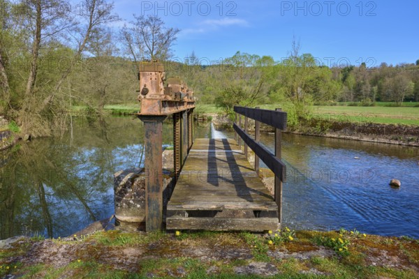 Wooden footbridge over a body of water in a natural setting with trees in the background, spring, Obersinn, Sinntal, Spessart, Bavaria, Germany