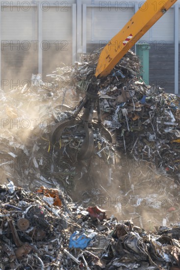 Hydraulic crane lifts scrap metal at the scrap yard