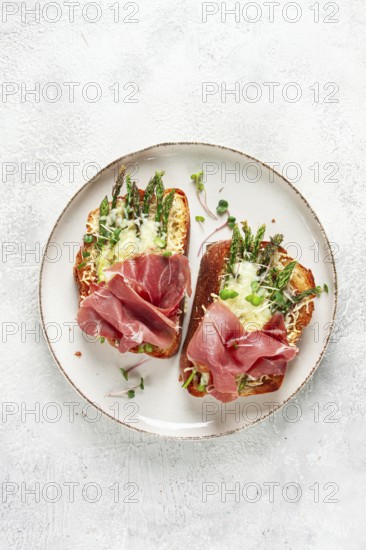Open sandwiches with asparagus and prosciutto, with cheese, breakfast, on a plate