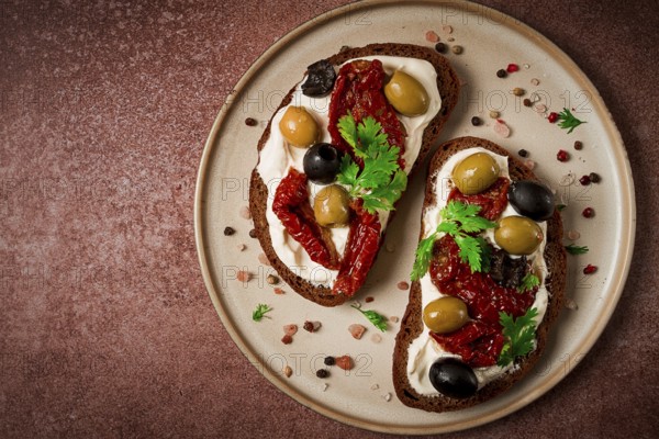 Sandwich with cream cheese, dried tomatoes, olives, breakfast, top view