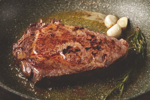 Fried steak, beef steak, rib eye steak, in a frying pan, top view, no people