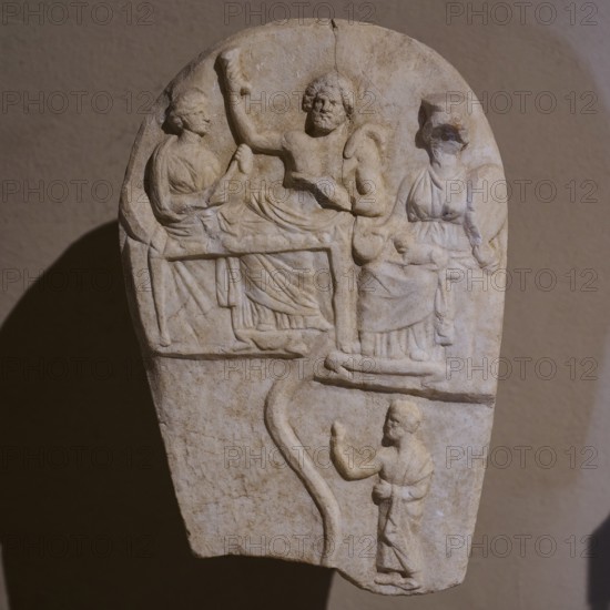 ©Udo Rein, Antique stone relief with several figures in scene, banquet of the dead, snake, Casa Romana, Kos Town, Kos, Dodecanese, Greek Islands, Greece