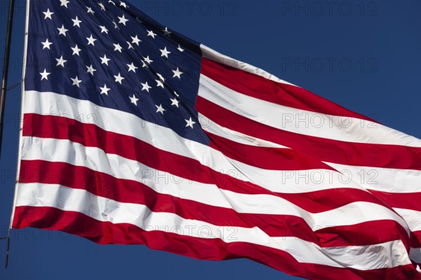 American flag waving in the wind against deep blue sky