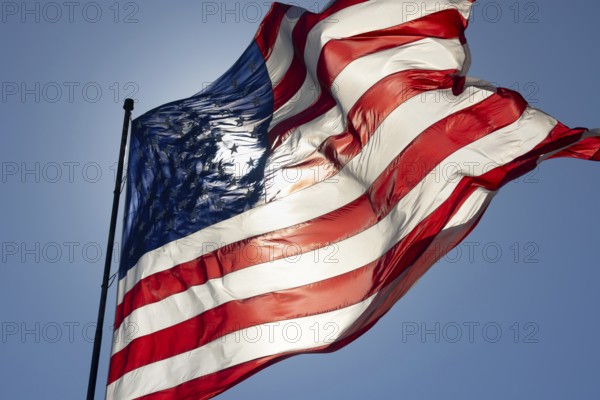 Dramatic backlit american flag waving in the wind
