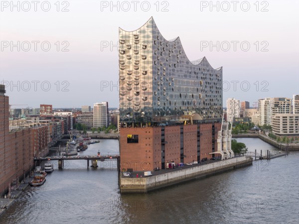 The Elbphilharmonie concert hall in Hamburg is reflected in the glass design above the historic Kaispeicher warehouse, Hamburg, Germany