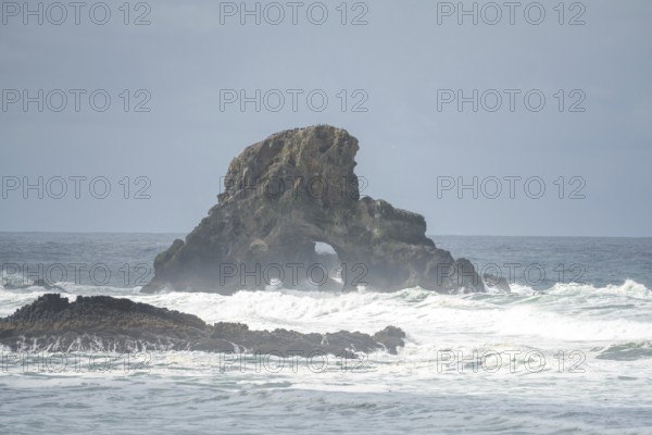 A rugged coastal landscape with rocks in the sea and a cloudy sky, Indian Beach, Oregon, USA, North America