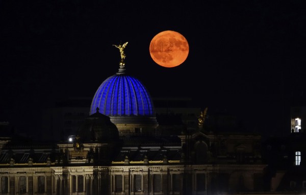 Glowing strawberry moon on 11 June 2025 over the Dresden University of the Arts, Saxony, Germany