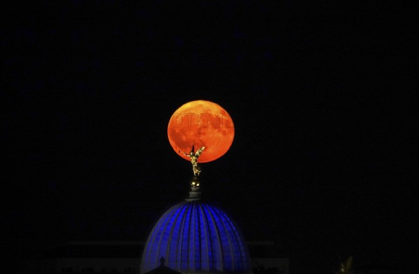 Glowing strawberry moon on 11 June 2025 over the Fama, Dresden University of the Arts, Saxony, Germany