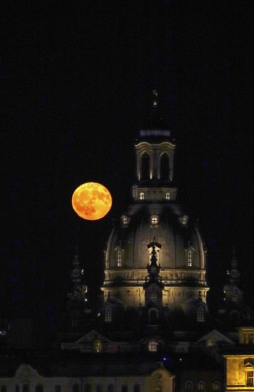 Glowing strawberry moon on 11 June 2025 next to the dome of the Church of Our Lady Dresden, Saxony, Germany