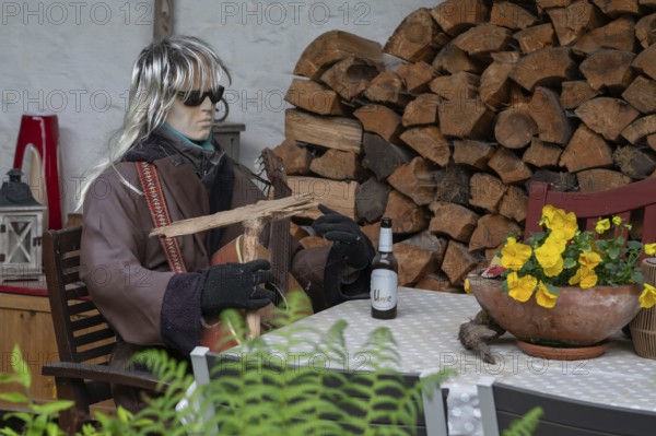 Sitting mannequin at a garden table, Bavaria, Germany