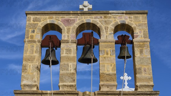 Church of Agios Ioannis Prodromos, Triple bell tower made of stone with blue sky in the background, Skala, harbour, Patmos, Dodecanese, Greek Islands, Greece